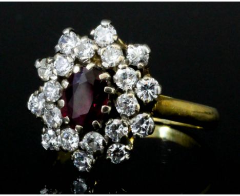 A modern 18ct gold mounted ruby and diamond oval cluster ring, set with a central ruby approximately .50ct surrounded by twen