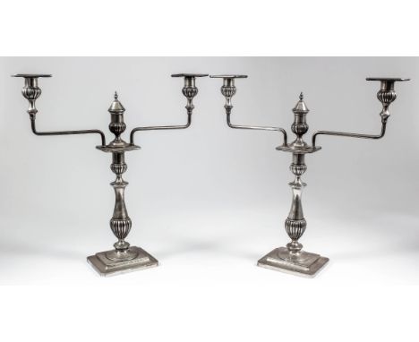 A pair of Indian silvery metal three light candelabra, the central columns with bulbous reeded knops and two angular branches
