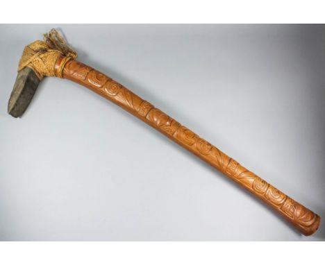 A 20th Century Polynesian stone headed war axe, with carved hardwood handle, 39ins overall