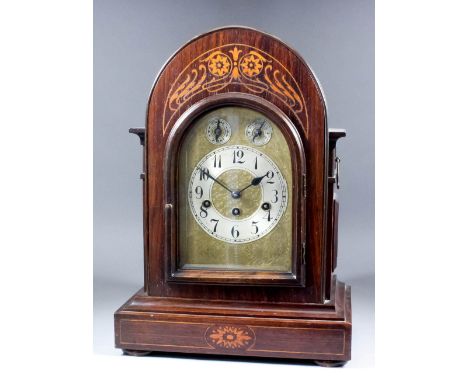 A late 19th Century German rosewood cased mantel clock by Junghans, the arched brass dial with silvered chapter ring with Ara