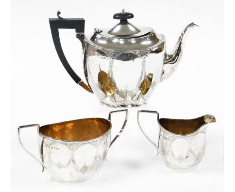 A George V silver Neo Classical design three piece tea service, bright cut decorated with bow drops, flowers and leaves, comp