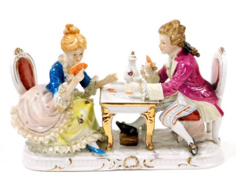 A Continental porcelain figure group, of card players in 18thC dress seated at a table, 26cm wide.