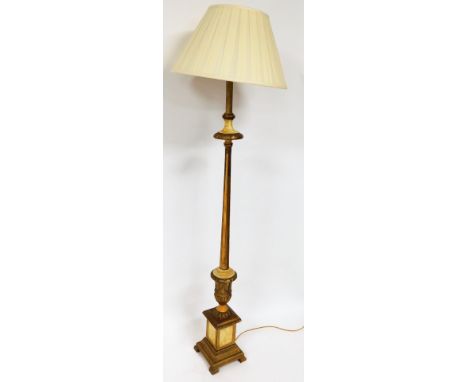 A gilt standard lamp, in gold with cream detailing, on a stepped base with cream shade, 172cm high.