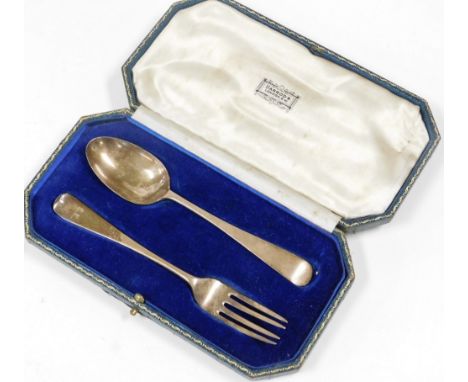 A silver cased christening set, retailed by Harrods of London, comprising fork and spoon, each bearing initial SE, London 193