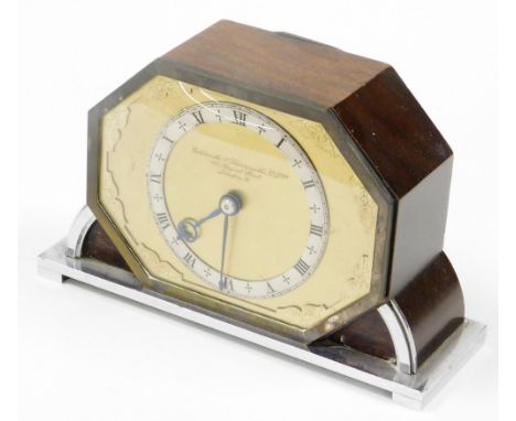 A Goldsmiths and Silversmiths Company Art Deco mantel clock, with octagonal front shield on gold coloured backing with silver