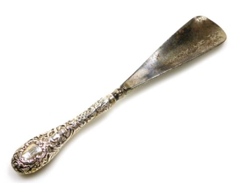 A silver handled shoe horn, bearing the initials MR, with cherub and foliate scrolling, 24cm long.