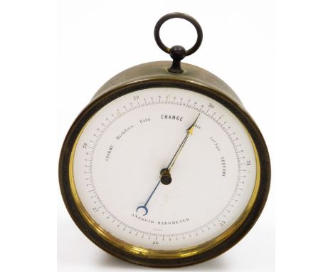 A brass aneroid barometer, with white ceramic dial and single loop bale, 12cm diameter.
