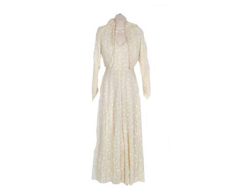 A 1950s lady's vintage wedding dress, the ivory full length dress in a floral lace over a satin ground with matching bolero w