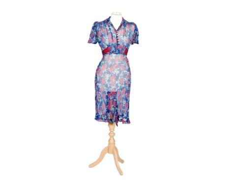 A 1930s lady's vintage chiffon tea dress in a pink floral print against a blue ground, the waist with a pink belt and fasteni