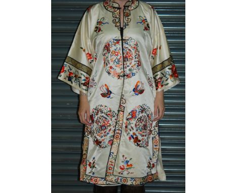 A lady's vintage Chinese kimono dress robe, the white satin ground with embroidered roundels, floral bands and butterflies, c