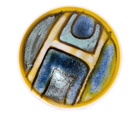 A Poole Pottery shape 49 Delphis pin dish coaster decorated with an abstract motif in tones of yellow, blue and green, printe