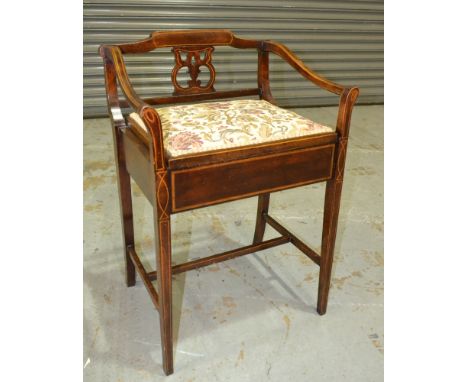 An early 20th Century line inlaid piano stool, with a pierced splat and rail sides above a lift up seat panel and H-form stre