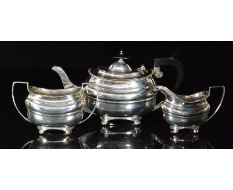 A George V hallmarked silver three piece tea service composed of teapot, sugar bowl and cream jug, each of oval form with gad