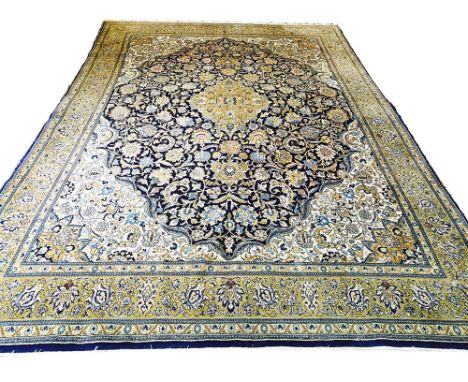 FINE PERSIAN QUM CARPET, 386cm x 260cm, golden medallion on a midnight blue field of palmettes and scrolling vines within ivo