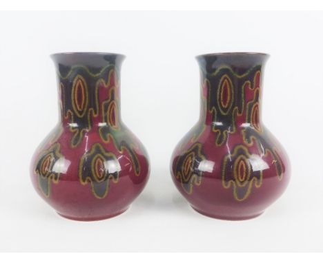 Plazuid Gouda pair of Art Pottery vases, each with red ground and dark green and yellow splash pattern, with printed backstam