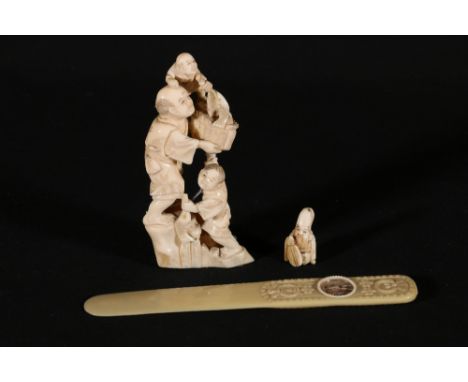 Japanese carved ivory okimono of a man with two children holding a basket and fish, a small ivory netsuke of Fukurukuju and a