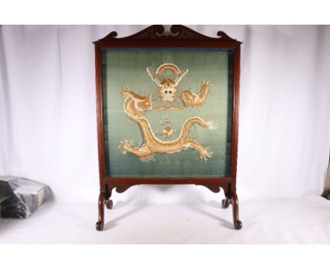 Early 20th century Chinese gold thread embroidered panel held withing a wooden firescreen with carved detail, the dragon work