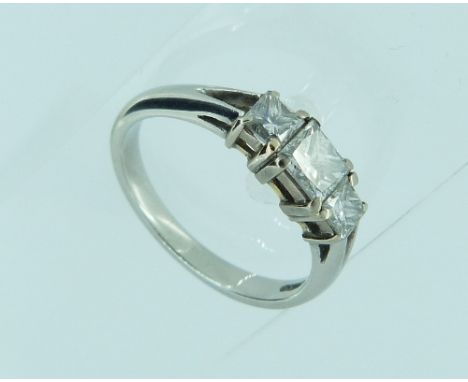 A platinum and diamond three stone Ring, the platinum shank with split shoulders and set with three princess cut diamonds, to