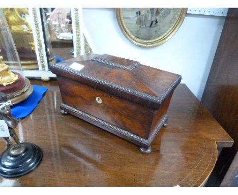 A William IV mahogany Tea Caddy, of sarcophagus form with beaded edges and bun feet, the hinged lid enclosing a pair of canis
