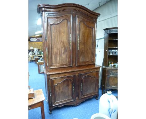 A large French 18thC provincial mahogany Buffet a deux corps (Armoire), the pair of shaped panelled doors enclosing three she