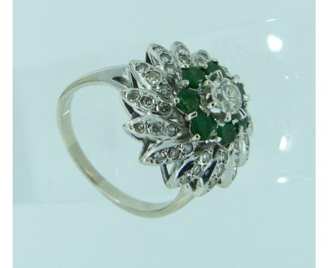 A dress Ring, of cluster form, with central brilliant cut diamond c.¼ct, surrounded by six emeralds and with fourteen petals 