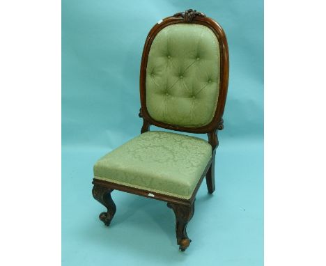 A Victorian carved walnut framed upholstered Parlour Chair, with button back.