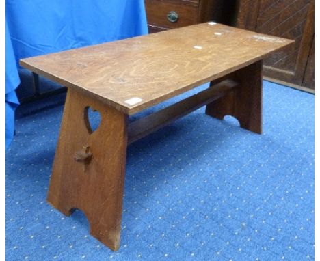 An Arts and Crafts oak Table/Bench, the end supports with heart shaped cut outs, 40in (102cm) wide.