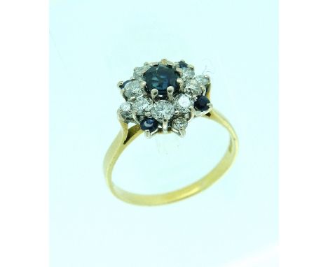 A sapphire and diamond cluster Ring, the centre with a circular sapphire surrounded by eight diamonds, with a further small d