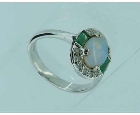 An attractive opal, emerald and diamond Ring, the central oval cabouchon opal with an emerald baguette on each shoulder, the 