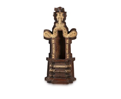 *A BALINESE CARVED WOOD AND IVORY MOUNTED BUDDHIST SHRINE 19th century the arched top with mask and mythical beasts above an 