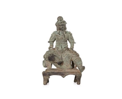 A SEATED BRONZE FIGURE OF GUANDI Modelled seated and tilted left, wearing armour with deep cast features, hands at hips and r