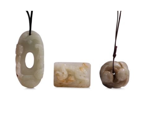 A GROUP OF THREE CELADON JADE CARVINGS (1) A rectangular plaque decorated in curled chilong, two pairs of mounting pinholes t