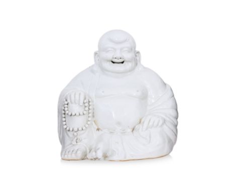 A LARGE BLANC DE CHINE PORCELAIN MODEL OF BUDAI
Modelled seated holding prayer beads in right hand, wearing robe and smiling 