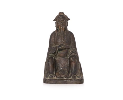 A PARCEL GILT SEATED BRONZE FIGURE OF GUANDI
Modelled wearing flowing robe and futou hat, seated with legs apart and holding 