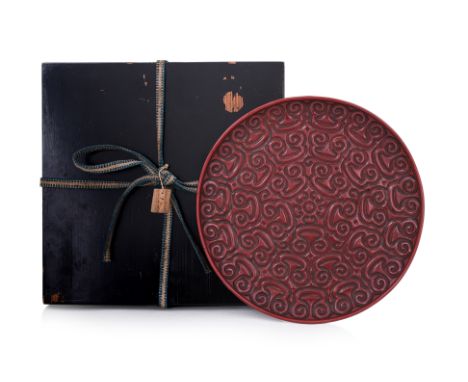 A CINNABAR LACQUER GURI DISH Circular dish decorated in layered relief carving, black lacquered base and foot 25.5cm diameter