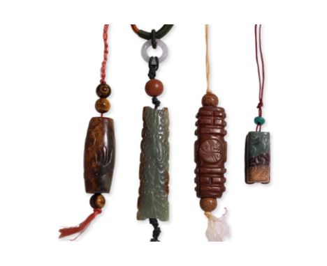 A GROUP OF FOUR JADE CARVINGS (1)
A rectangular celadon and russet toned pendant with archaistic patterned exterior, on a fab