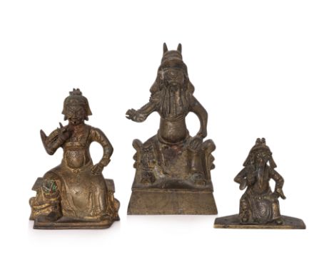 A GROUP OF THREE BRONZE FIGURES OF GUANDI
The tallest example modelled seated on throne with curved sides, wearing robe over 