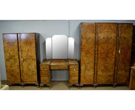 An Art Deco walnut bedroom suite, comprising: a three-door wardrobe, the caddy top above three walnut veneered doors enclosin