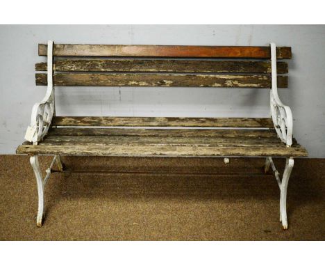 An early 20th Century cast iron garden bench, with slatted back and seat, contained within scroll metalwork supports, raised 