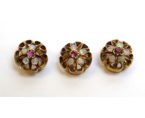 Three late 19th/early 20th Century opal and ruby shirt studs, in yellow metal mounts, (missing some opals), 5.2g gross.