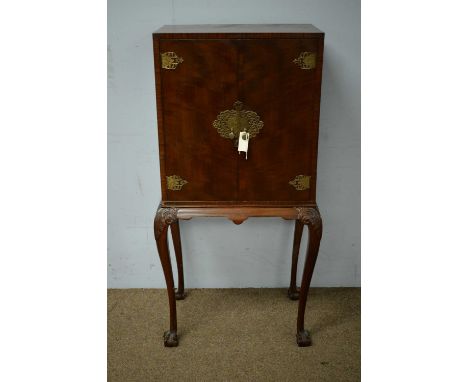 A 20th Century mahogany cocktail cabinet in the Chinese style, the caddy top above a pair of brass-mounted cupboard doors enc