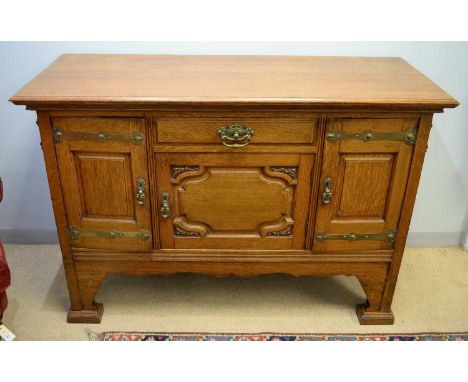 An early 20th Century oak dresser base in the style of Shapland &amp; Petter, the rectangular top above a central frieze draw