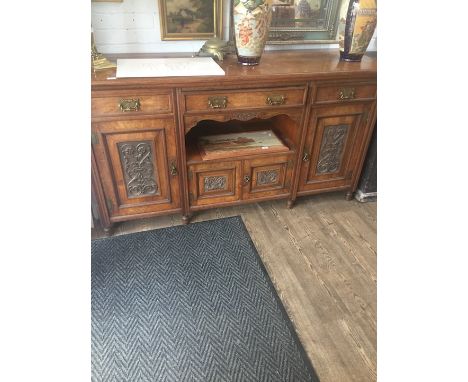 A 19th century sideboard with carved panel doors and aesthetic brass handles 