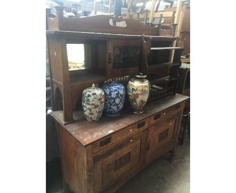 An Arts &amp; Crafts oak mirror back sideboard in the manner of Liberty &amp; Co with beaten copper panel and strap hinges 