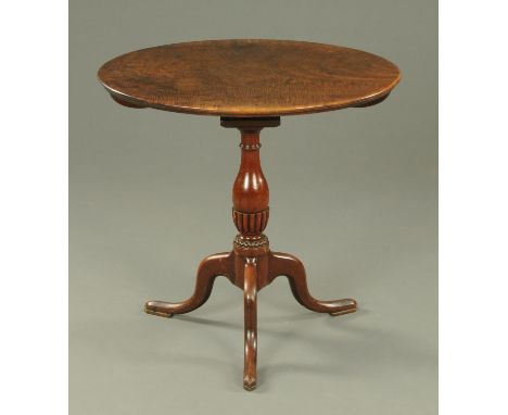 A George III mahogany tripod table, with oval top with bird cage support, with turned and lobed column and three downswept le