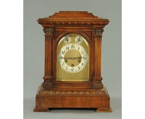 An Edwardian walnut bracket clock, with three-train spring driven movement striking on five gongs.  Width 34 cm, height 43 cm