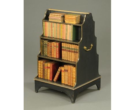 A painted pine double sided waterfall bookcase, partially gilt, with carrying handle to either side and raised on bracket fee