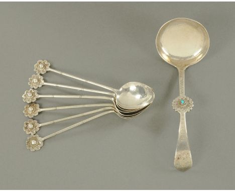 A set of six Tibetan silver metal teaspoons, with planished bowls and simulated bamboo stems terminating in a flower, and a T