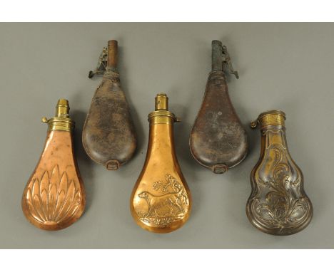 A copper powder flask, embossed with labrador and tree, the brass top with volume measure, a copper shot flask with leaf desi