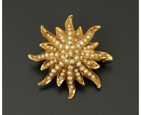 A 14 ct gold sunburst seed pearl brooch/pendant, stamped "14 k".  Width 36 mm.    CONDITION REPORT:  The brooch is structural